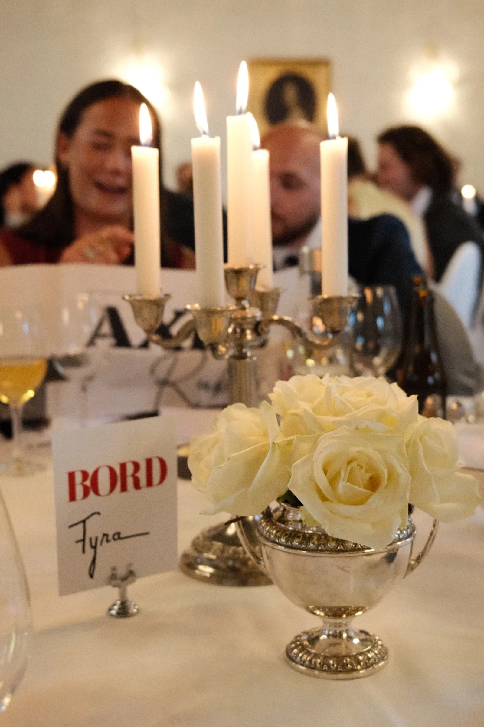 Dukat bord med levande ljus, vita rosor och bordsplacering