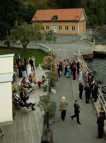 Gästerna samlas på bryggan vid det gula huset, sett ovanifrån